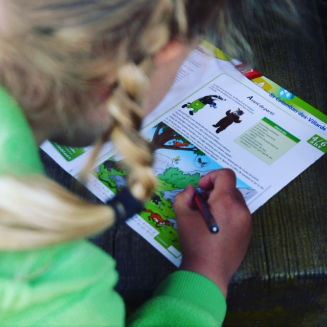 enfant écrivant sur le document de Randoland enfant écrivant sur le document de Randoland